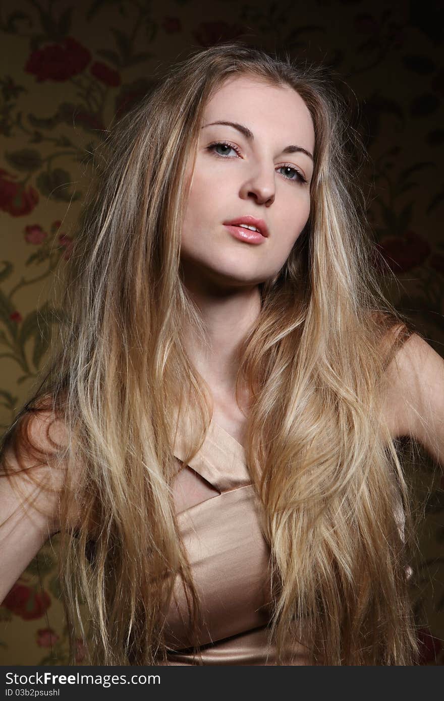 Portrait of the beauty young blond girl near the wall with roses