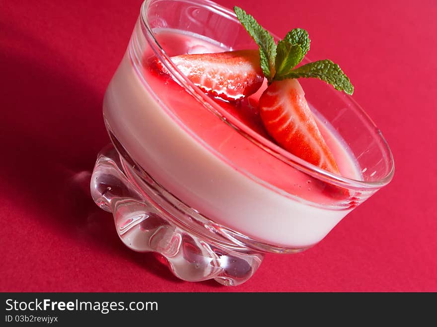 Italian dessert panna cotta on white plate decorated with strawbery, mint and fruit syrup. Italian dessert panna cotta on white plate decorated with strawbery, mint and fruit syrup