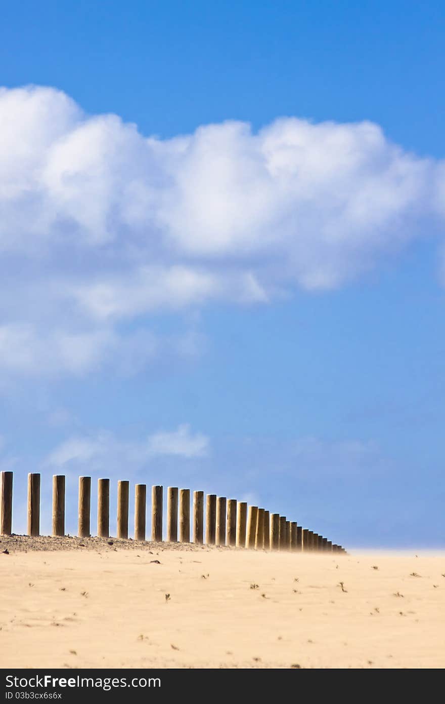 Wooden fence disappearing into the infinity of the dessert.