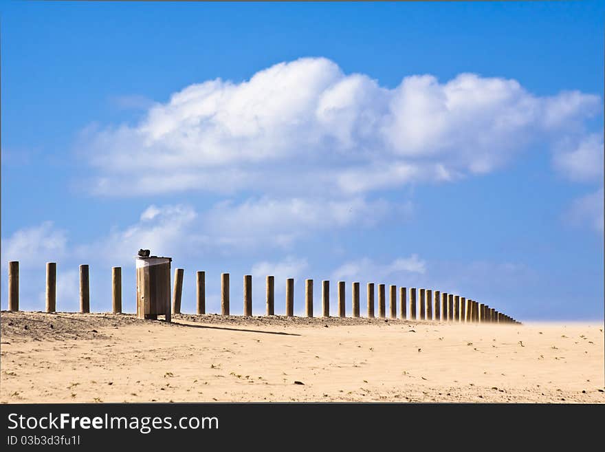 Wooden waste bin along the road disappearing into the infinity of the dessert. Wooden waste bin along the road disappearing into the infinity of the dessert.