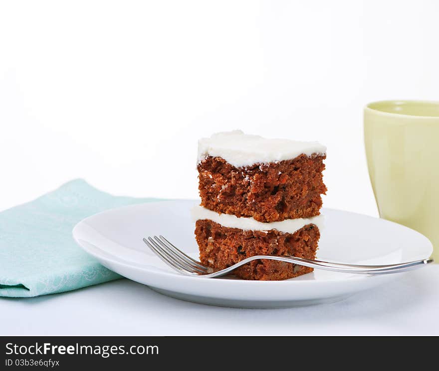 Carrot cake with butter cream frosting on white plate. Carrot cake with butter cream frosting on white plate