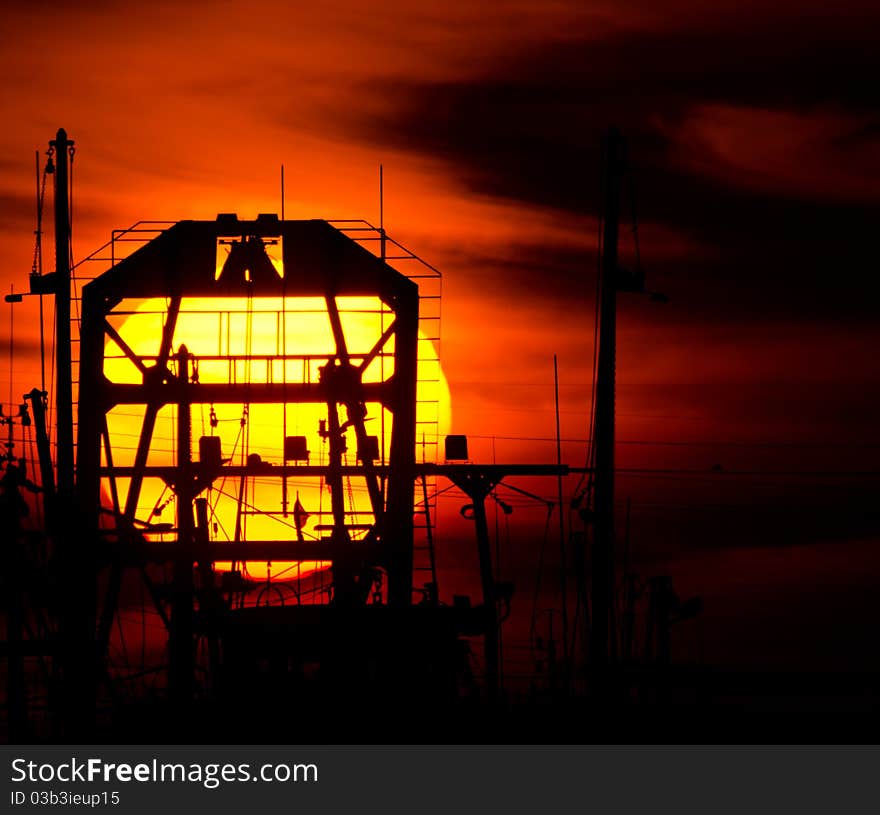 Sun setting behind silhouette of fishing boat. Sun setting behind silhouette of fishing boat