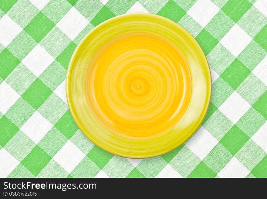 Round Yellow Plate On Green Checked Tablecloth