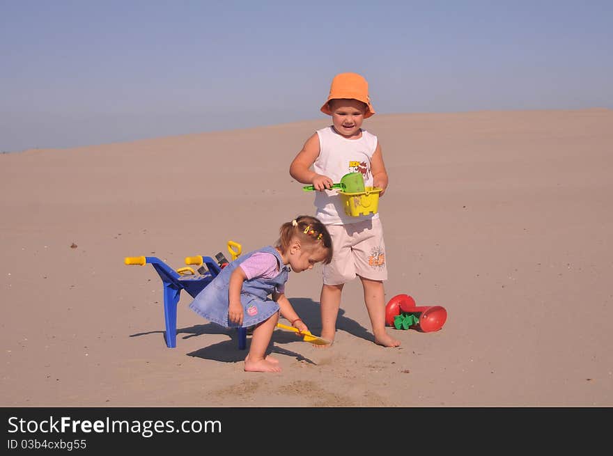 Children play in sand with toys