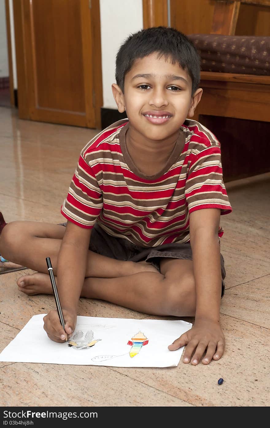 An handsome Indian kid doing his homework very happily