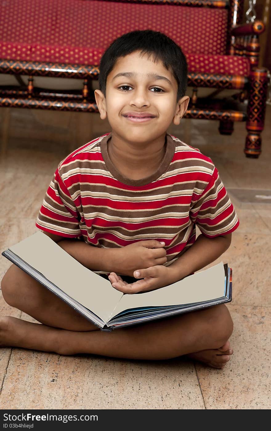 An handsome Indian kid doing his homework very happily