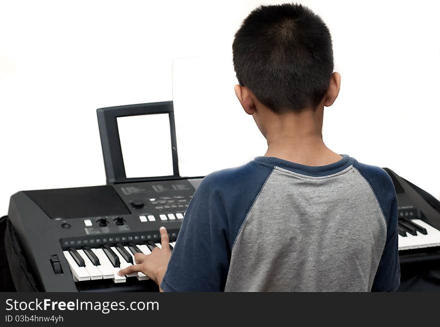 An handsome Indian boy learning music with an electric piano