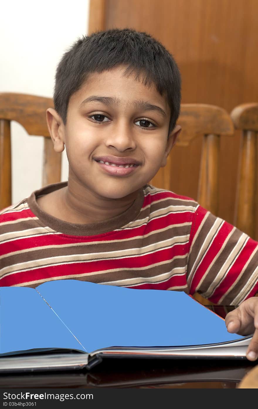 An handsome Indian boy learning music with an electric piano