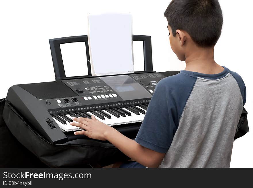 An handsome Indian boy learning music with an electric piano