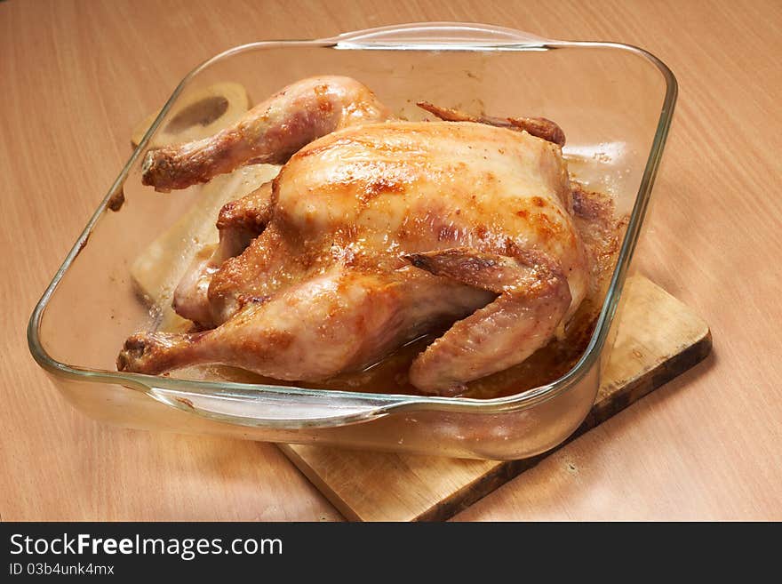 A grilled chicken in glass pan