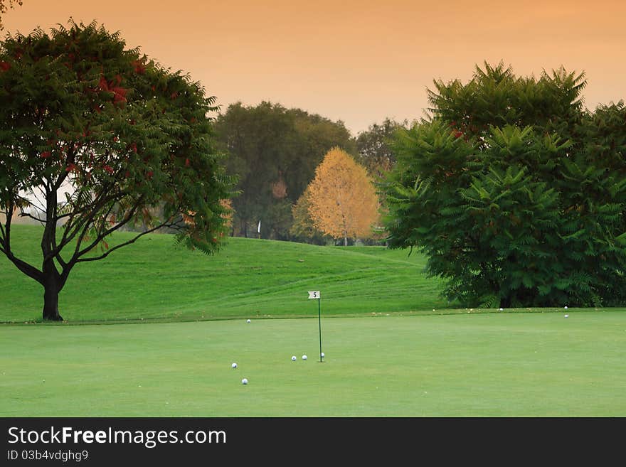 Golf meadow with green grass and smokie sky