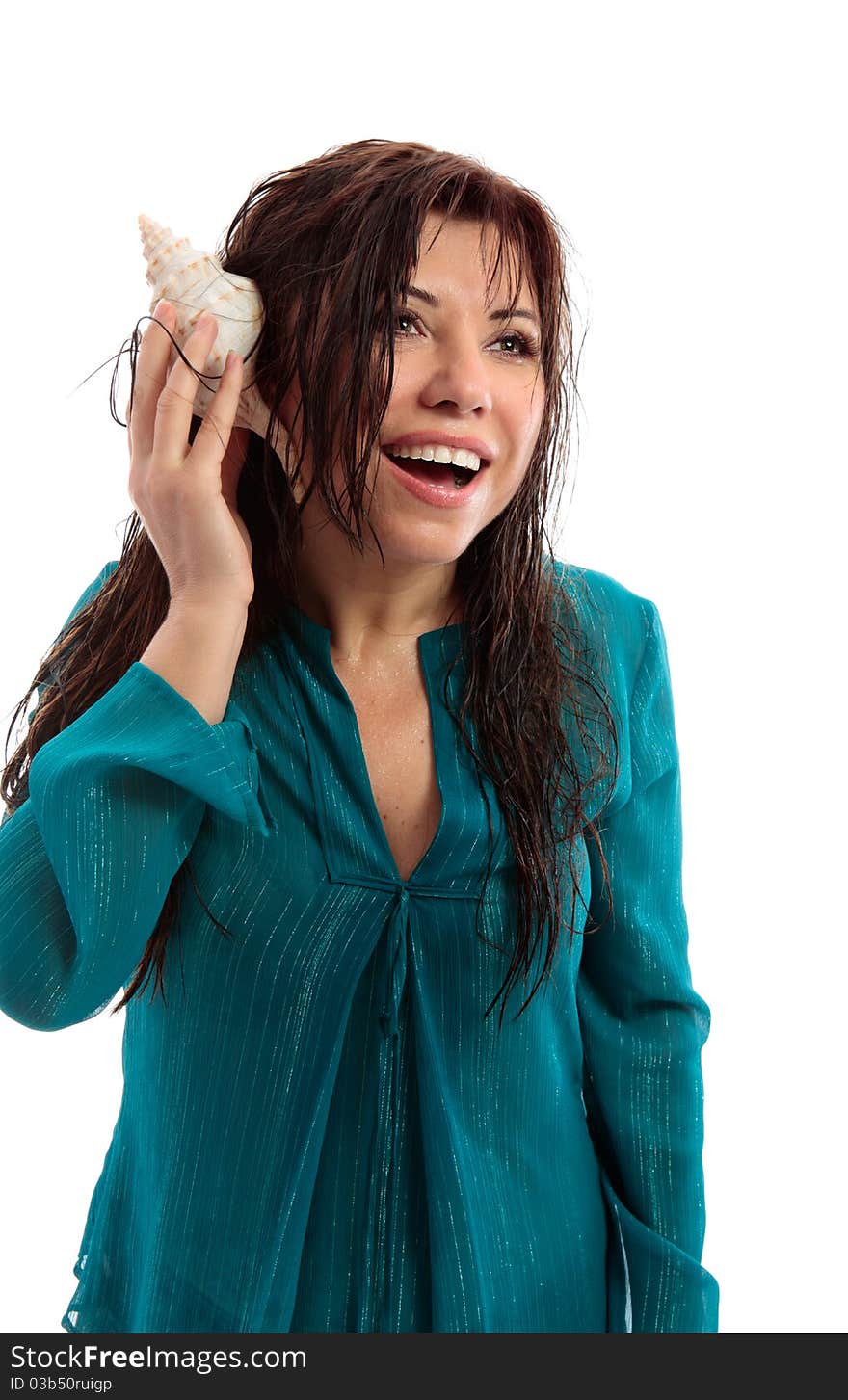 A beautiful woman with wet skin and hair holding a seashell to her ear and with a vivacious open smile. A beautiful woman with wet skin and hair holding a seashell to her ear and with a vivacious open smile.