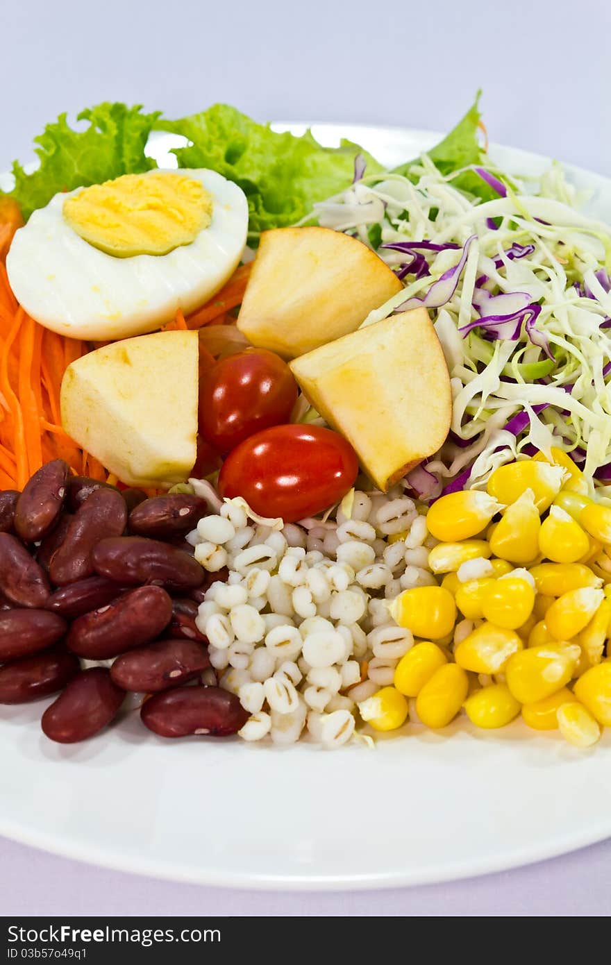 Fruit salad with boiled egg on a white plate