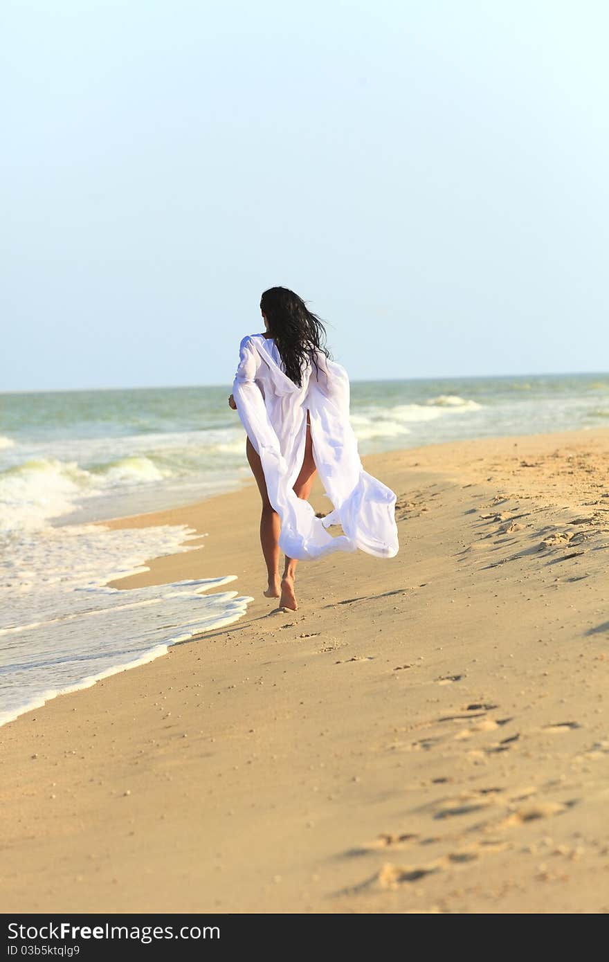 The girl in white coat at the beach