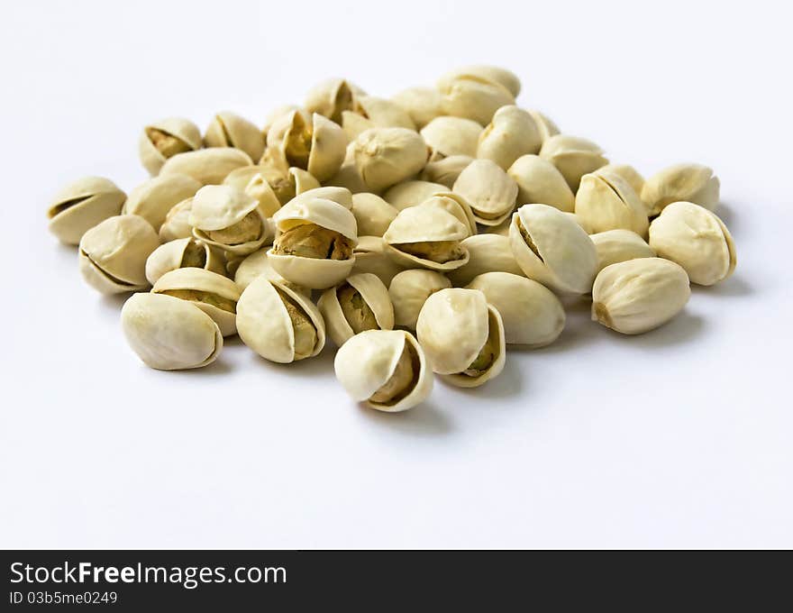 Pistachio nuts with shell in shallow depth of field on seamless background. Pistachio nuts with shell in shallow depth of field on seamless background.