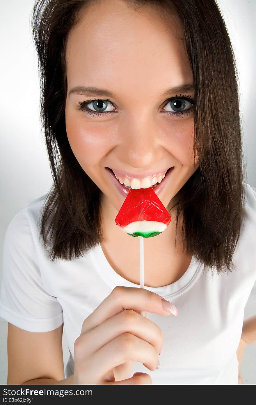 Pretty girl with candy on a white background