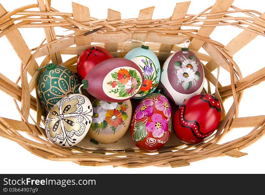 Painted easter eggs in basket with white background