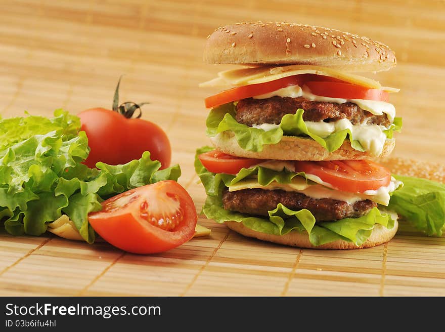 Hamburger with cutlet and vegetables on bamboo napkin