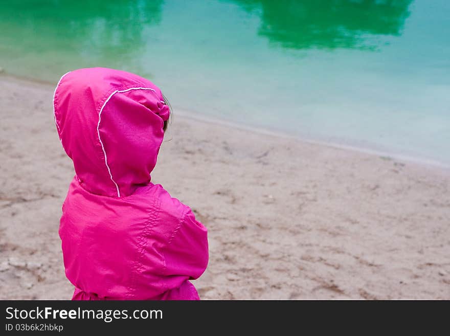 Young girl contemplating a pond. Young girl contemplating a pond