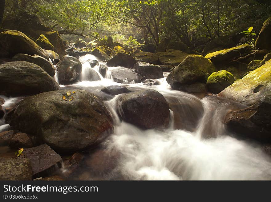 Cascade falls over old plum river with rocks for background or other purpose use