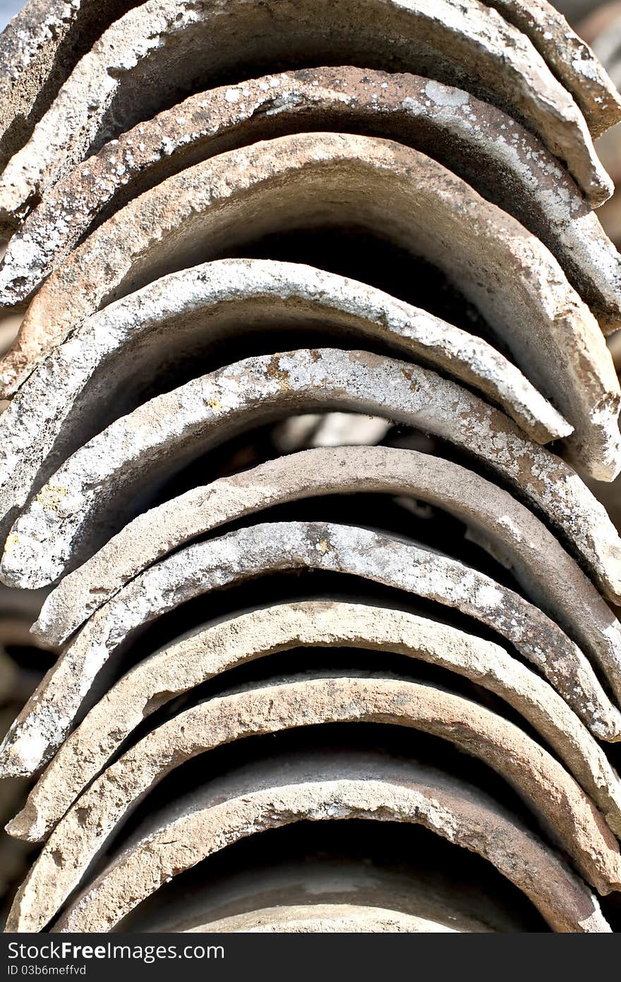 Close up of old Weathered, stacked cylindrical clay roof tiles,