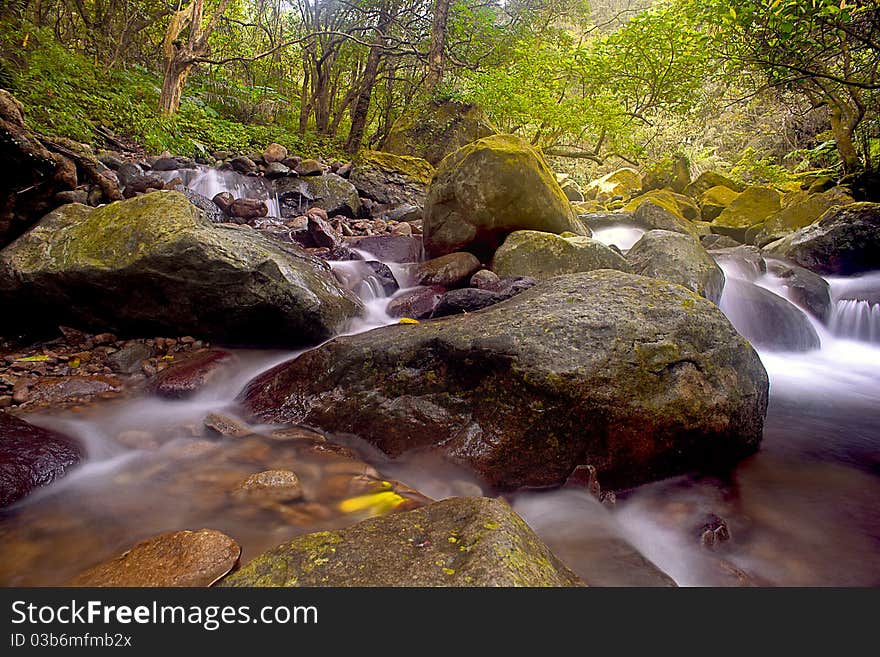 Cascade falls over old plum river with rocks