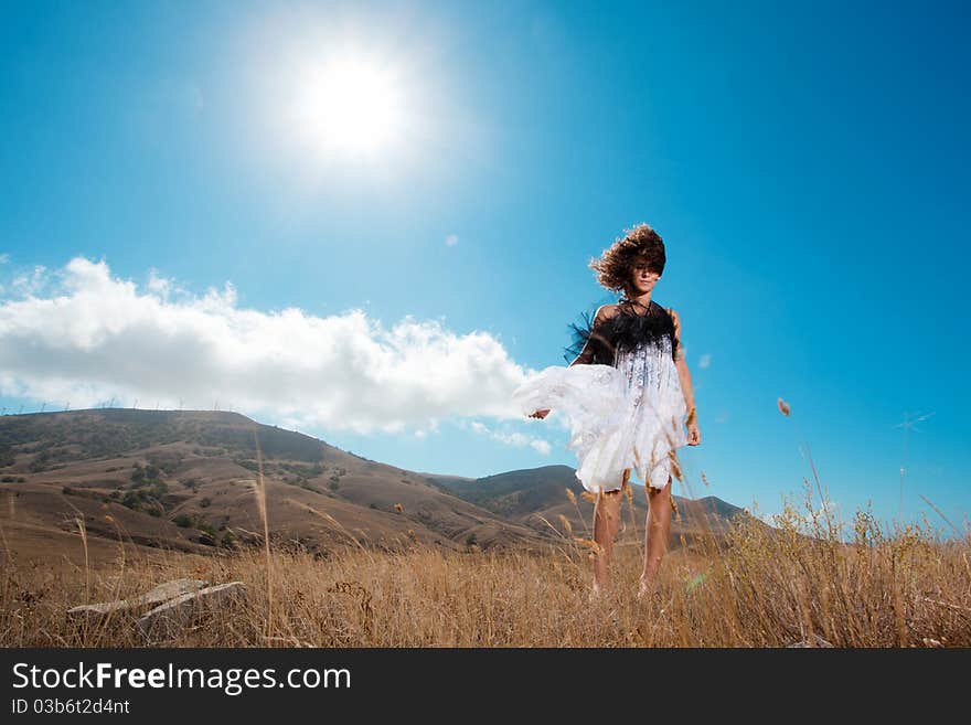 Beautiful young woman relaxing outdoors on the hills and meadows