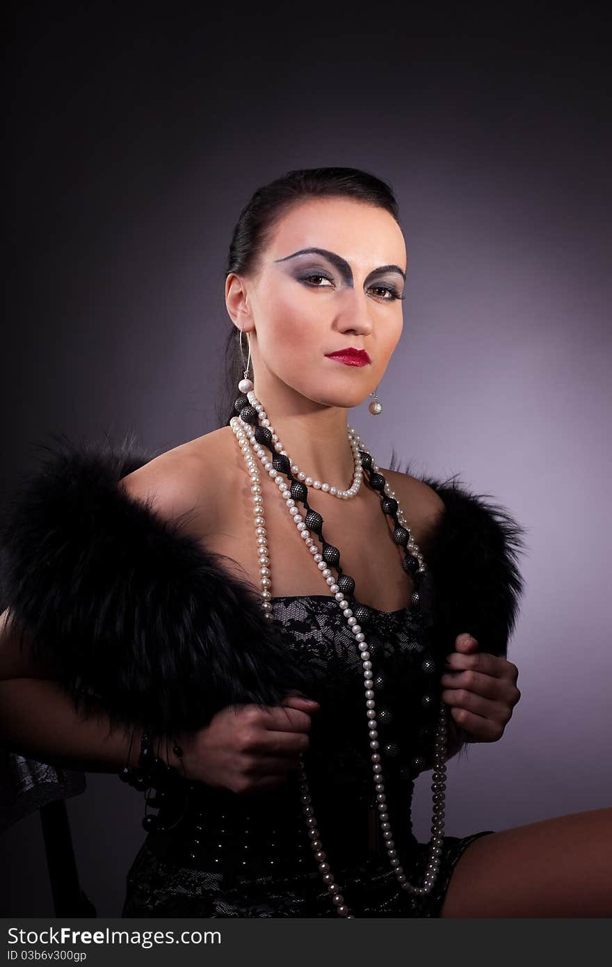 Young woman in fur boa with pearl beads retro syle