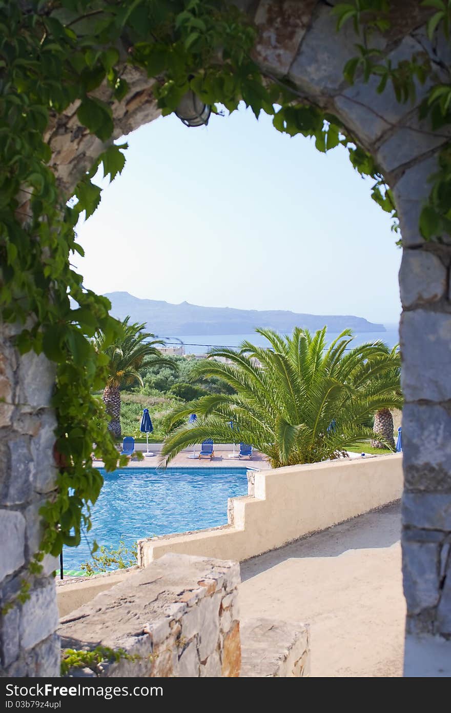 Swimming pool with sunbed seen through arc. Swimming pool with sunbed seen through arc