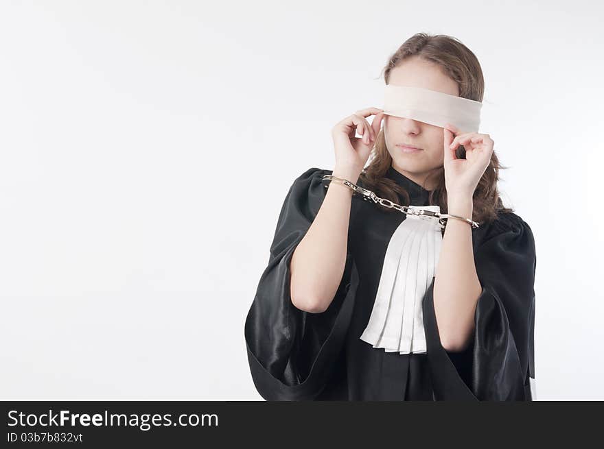 Young law school student holding statute books blindfolded and handcuffed. Young law school student holding statute books blindfolded and handcuffed