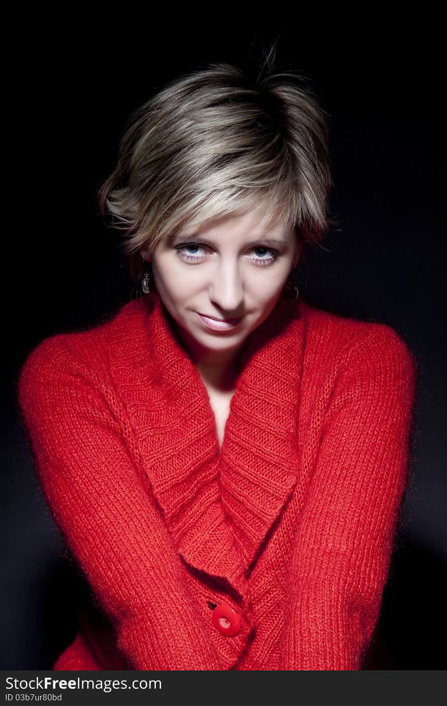 Portrait of attractive woman in red pullover on black background