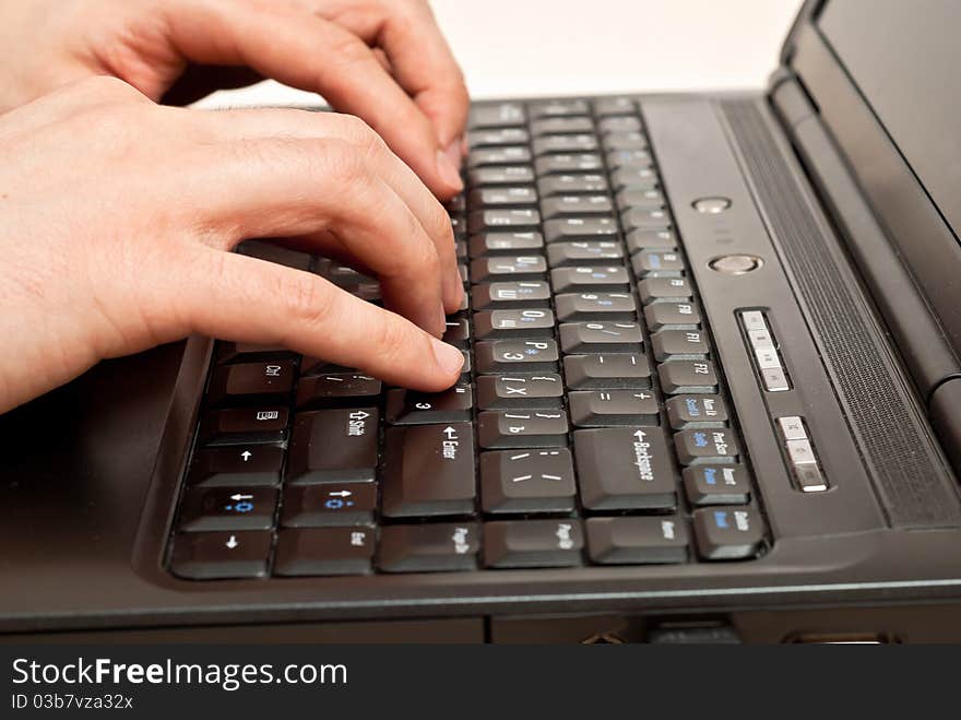 Male hands typing on a laptop keyboard. Male hands typing on a laptop keyboard