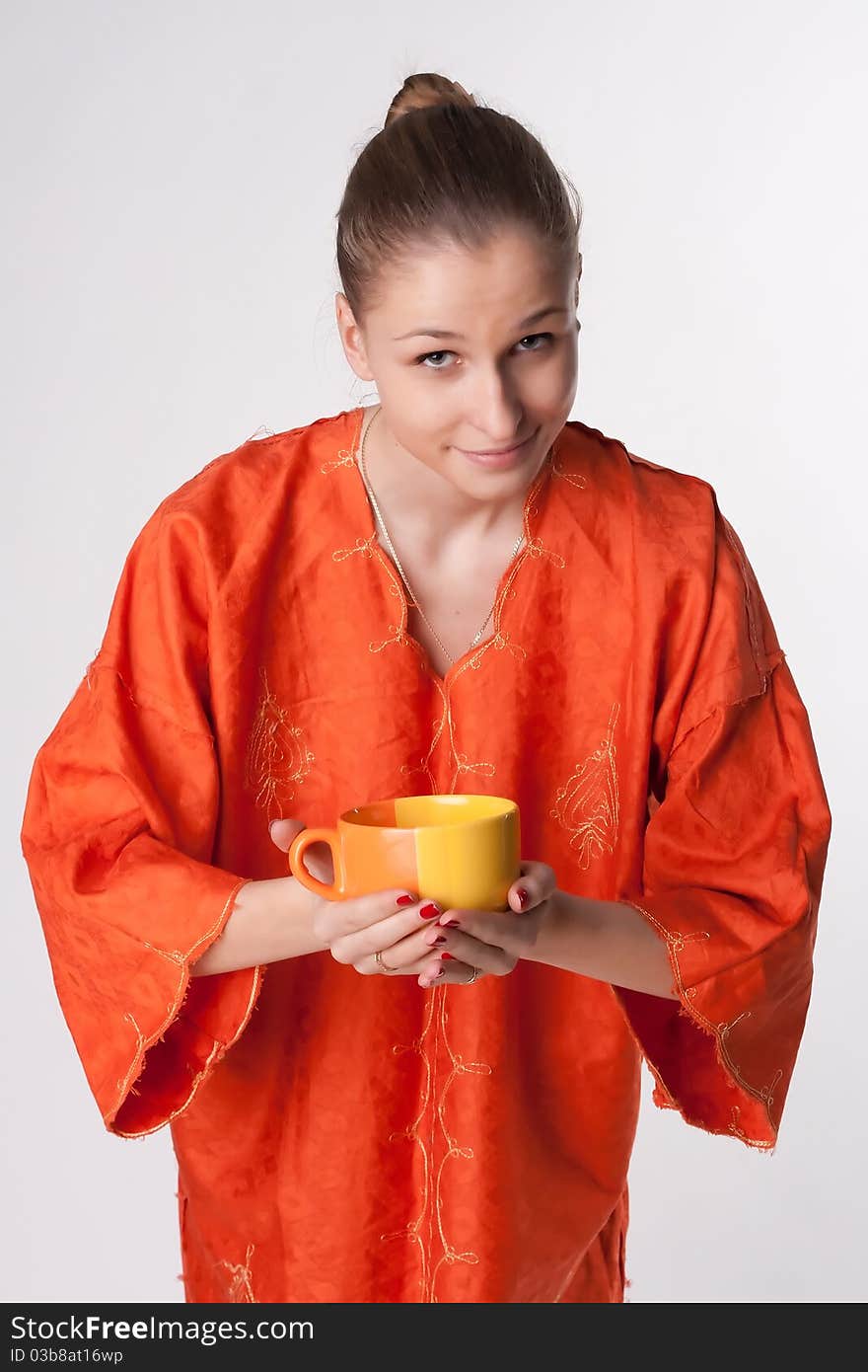 Girl In Orange Dress With A Cup