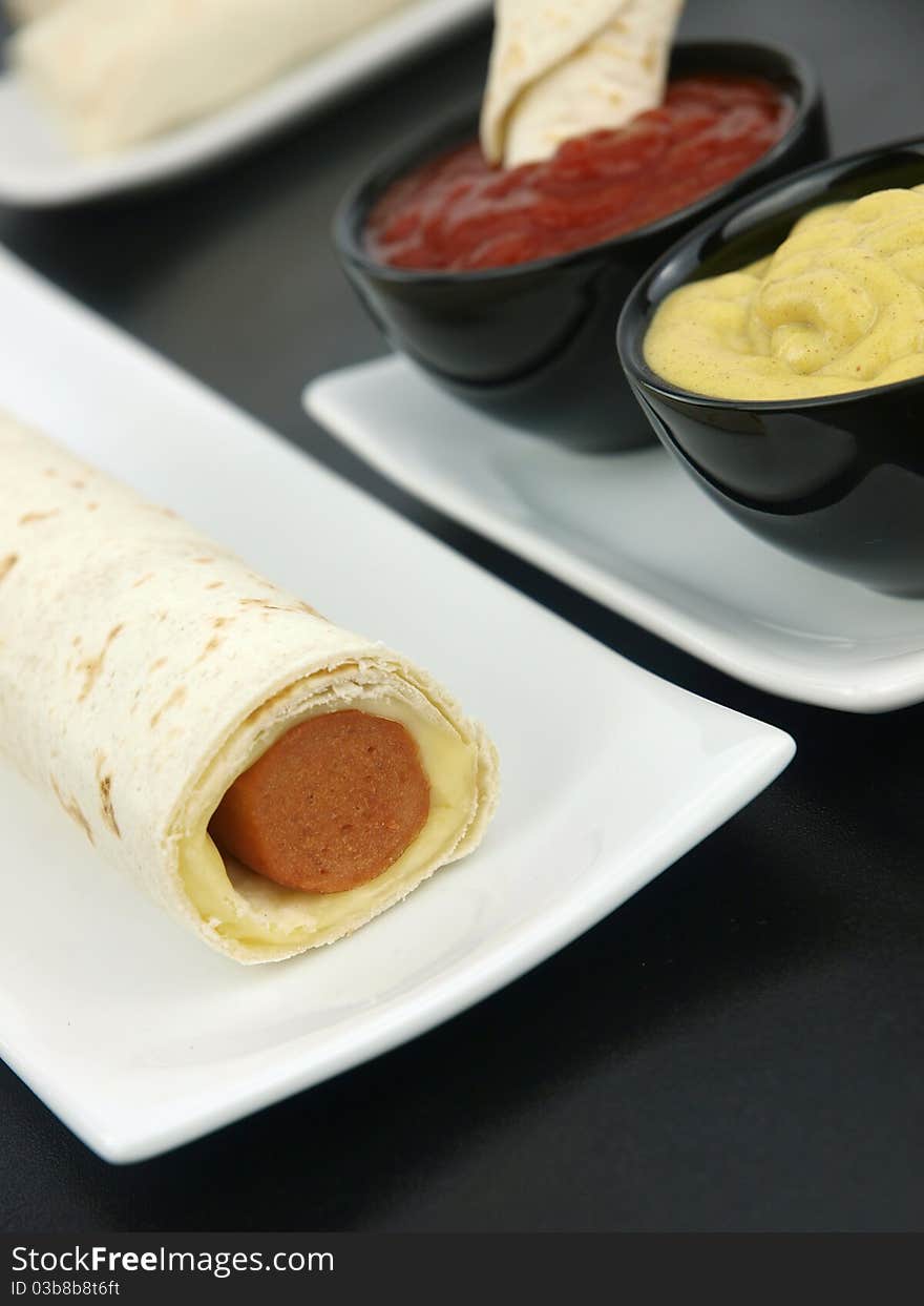 Tortilla wrap with sausage on a plate. Tortilla wrap with sausage on a plate