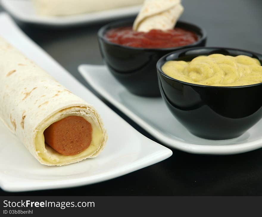 Tortilla wrap with sausage on a plate. Tortilla wrap with sausage on a plate