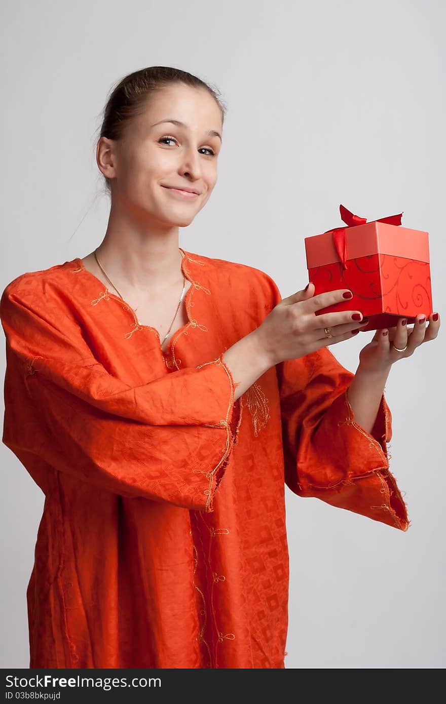 Smiling Girl In An Orange Background With A Gift