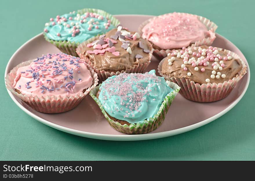 Homemade cupcakes with frosting on a pastell table