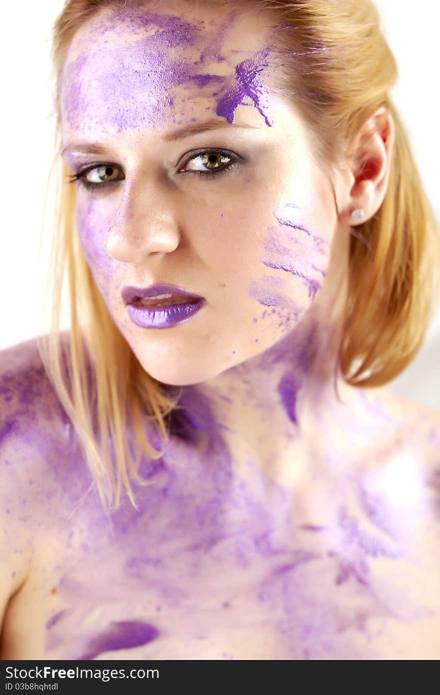 Concept studio portrait of a young woman smeared in purple ink on white. Concept studio portrait of a young woman smeared in purple ink on white