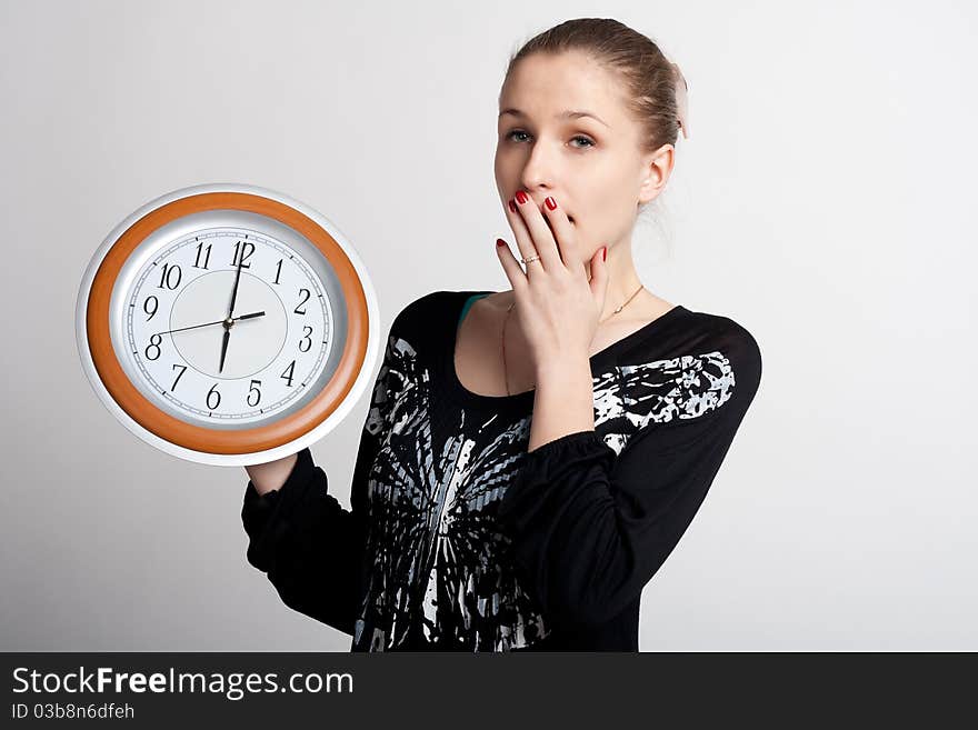 Sleeping girl on a white background with a big clock in the hands of which 6 am. Sleeping girl on a white background with a big clock in the hands of which 6 am