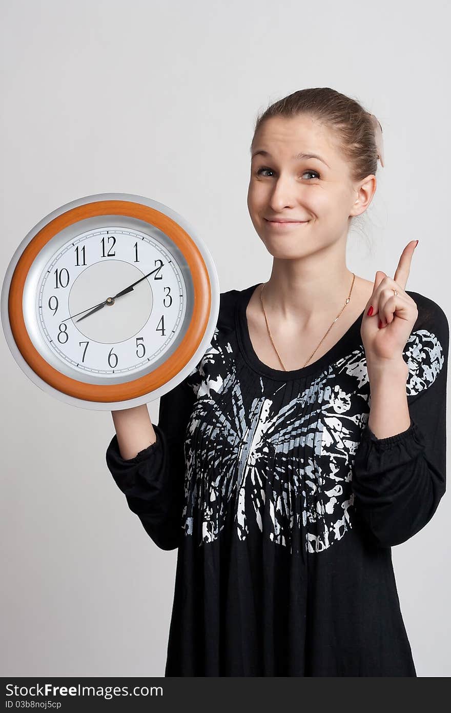 Beautiful girl with a big clock in his hands