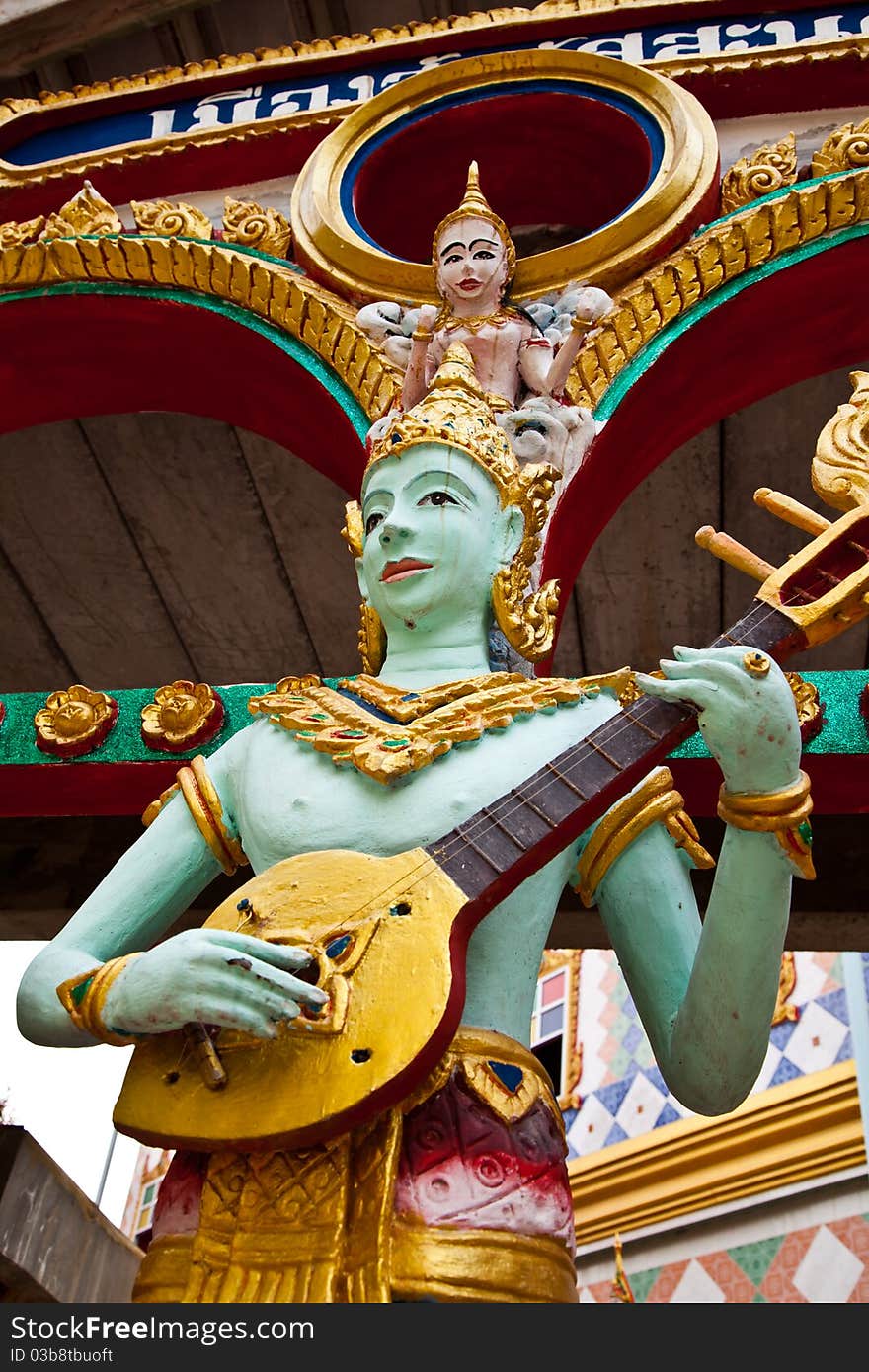 Crying fairy string player stucco in Thai traditional art and craftsmanship at a rural Thai temple.