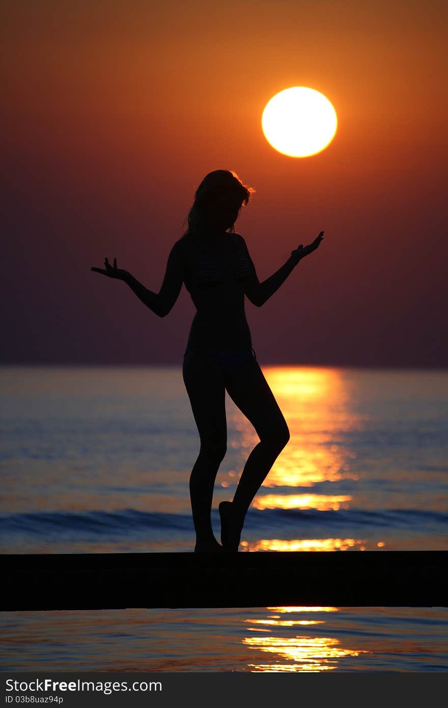 Girl posing on a bridge when sun lower to sea. Girl posing on a bridge when sun lower to sea.