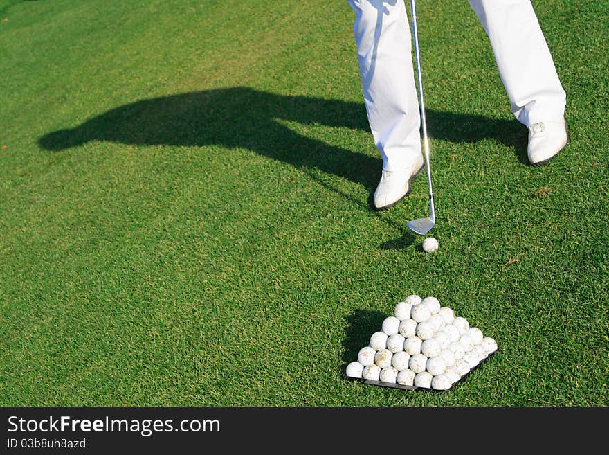 Golfer ready to strike. Low angle camera view.