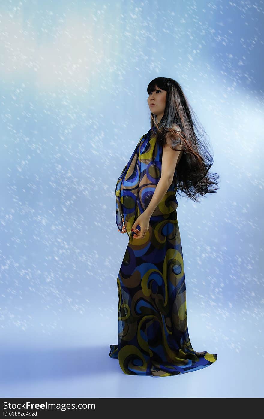 Asian pregnant woman in transparent dress on blue background with radiance. Asian pregnant woman in transparent dress on blue background with radiance