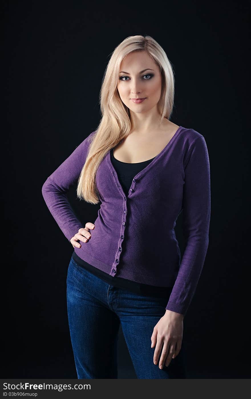 Portrait of beauty blonde girl in lilac top and jeans on black background. Portrait of beauty blonde girl in lilac top and jeans on black background