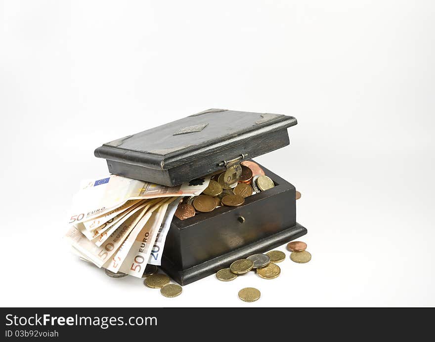 Photo of an old box full with coins and banknotes