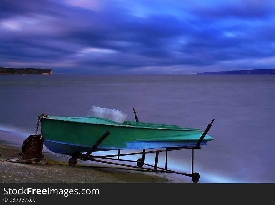 Boat on the bank of a lake at sunset