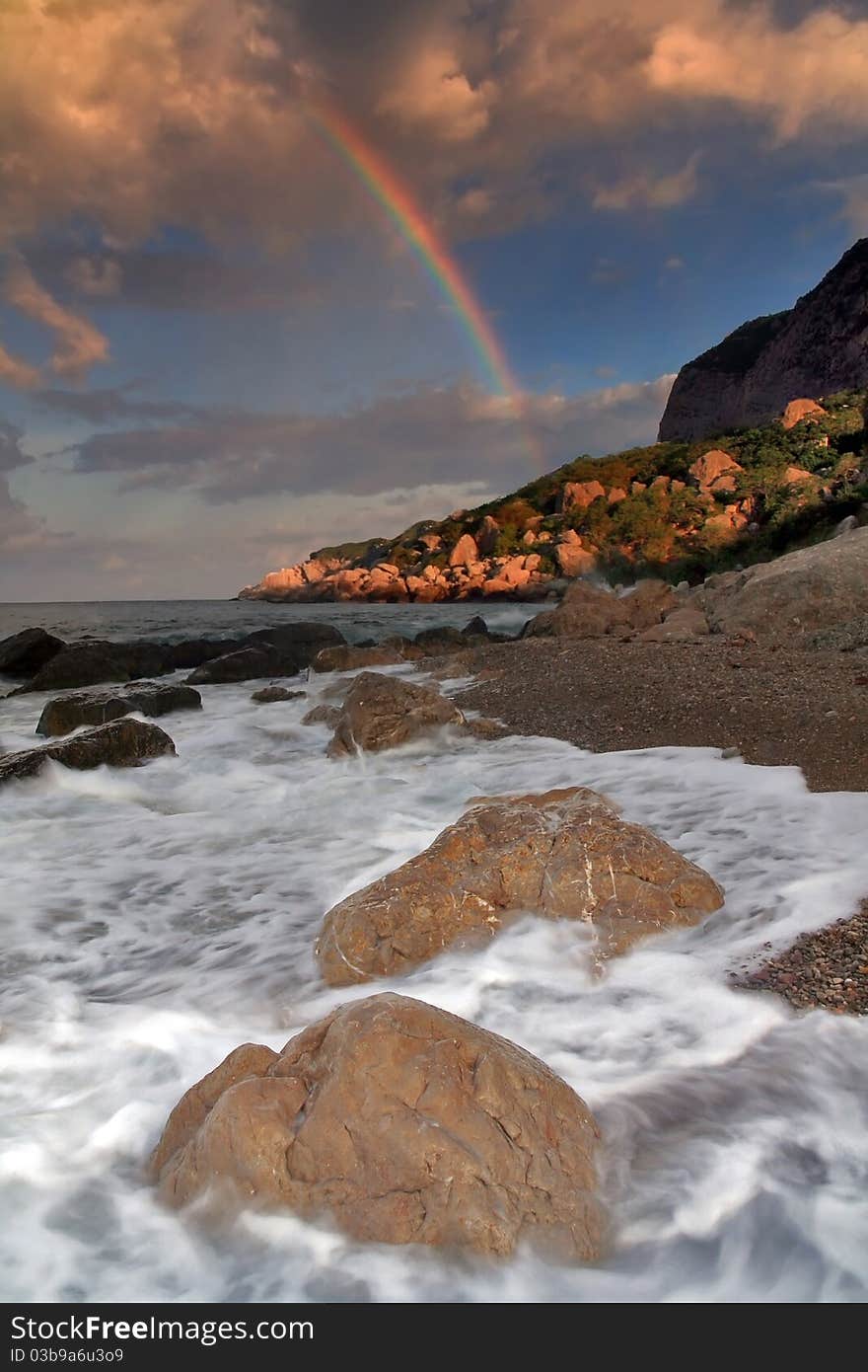 Rainbow over stormy sea in the early morning