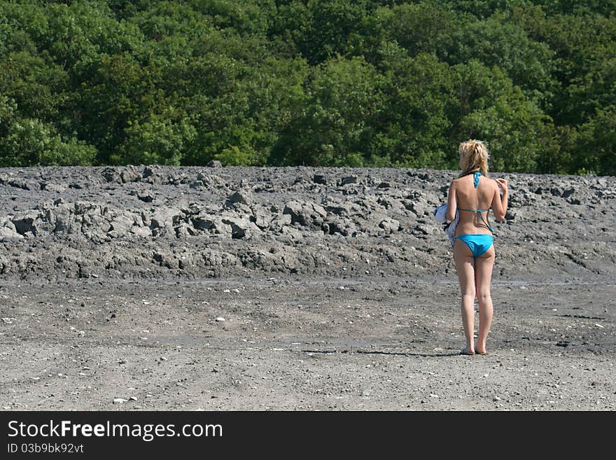 Girls stands at mud vulcano.