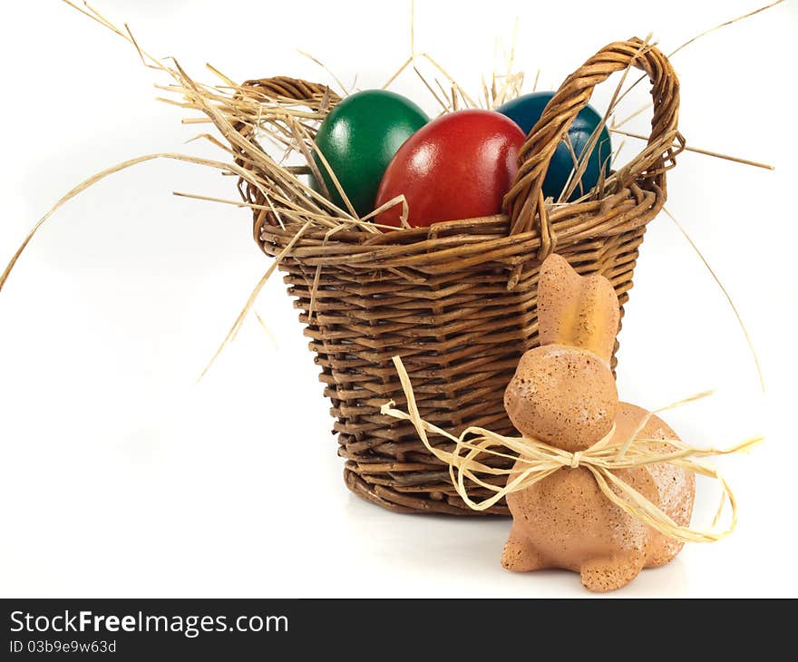 Easter Rabbit in front of a basket with three easter eggs. Easter Rabbit in front of a basket with three easter eggs